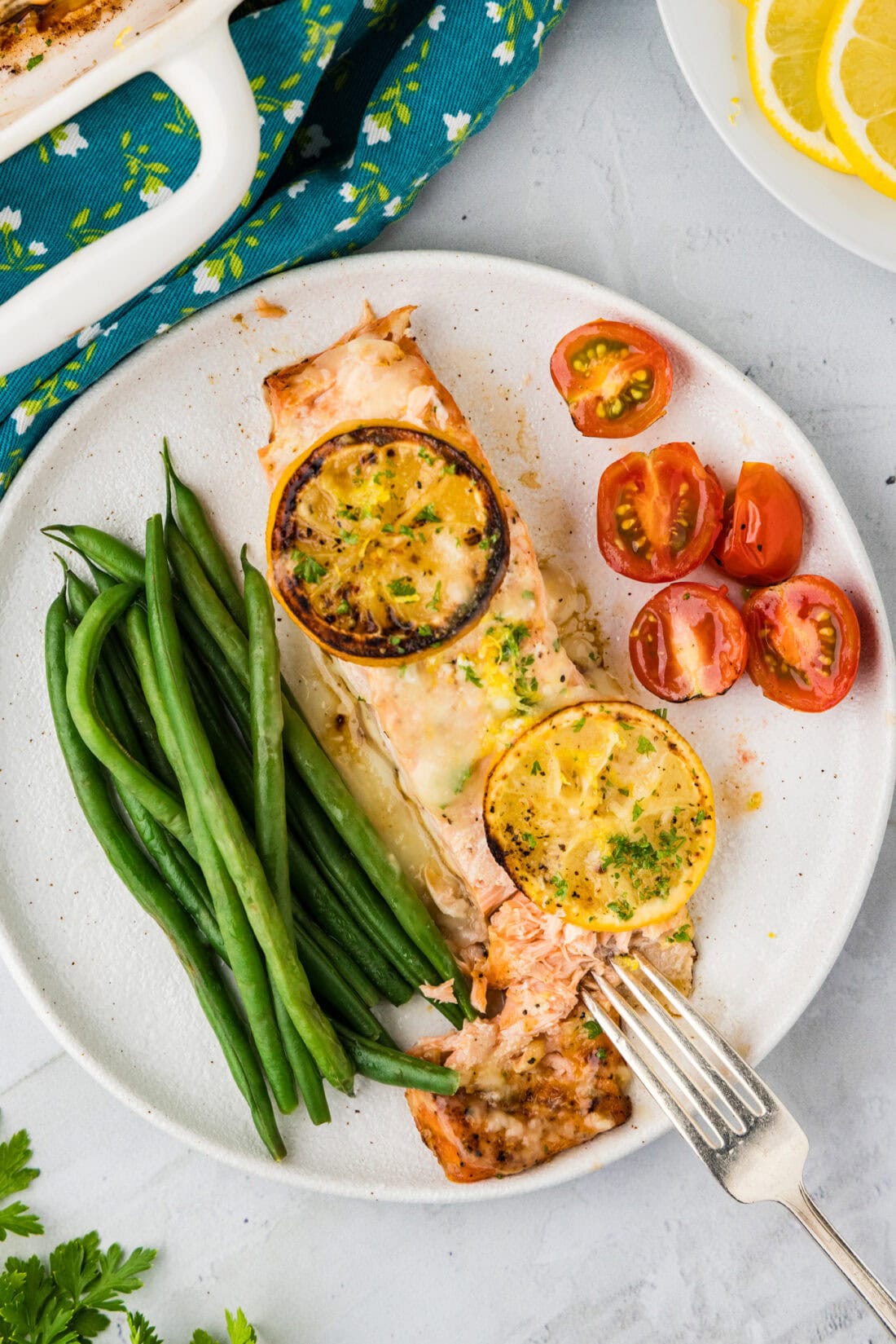 Baked Lemon Salmon on a plate with asparagus and tomatoes