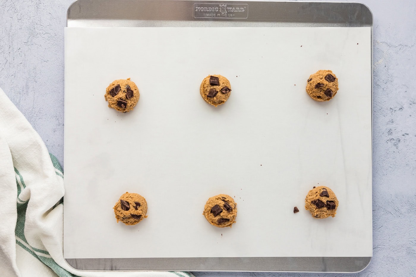 chocolate chip espresso cookie dough balls on a insulated baking sheet