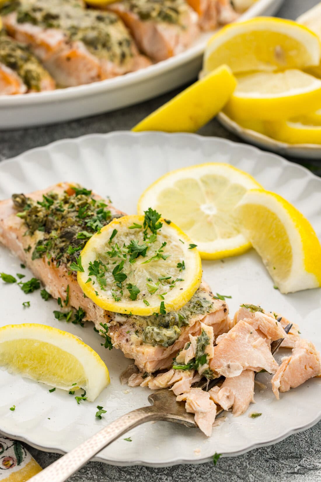 Lemon Caper Salmon filet broken apart on a plate