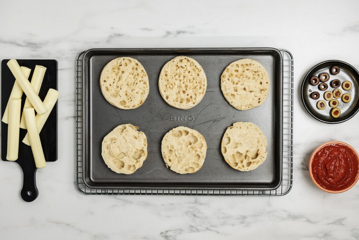 toasted English muffins on a baking sheet