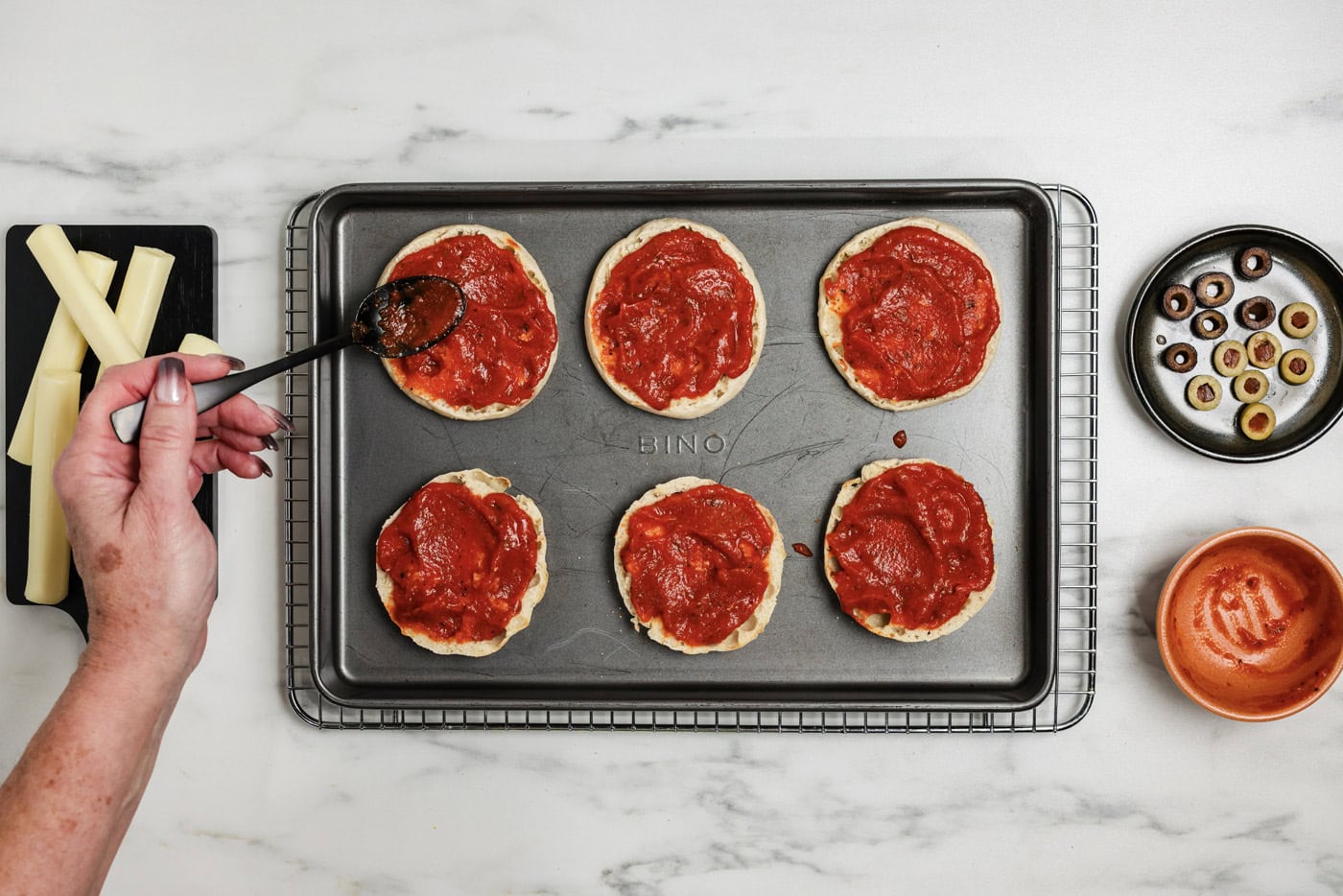 basting English muffins with pizza sauce