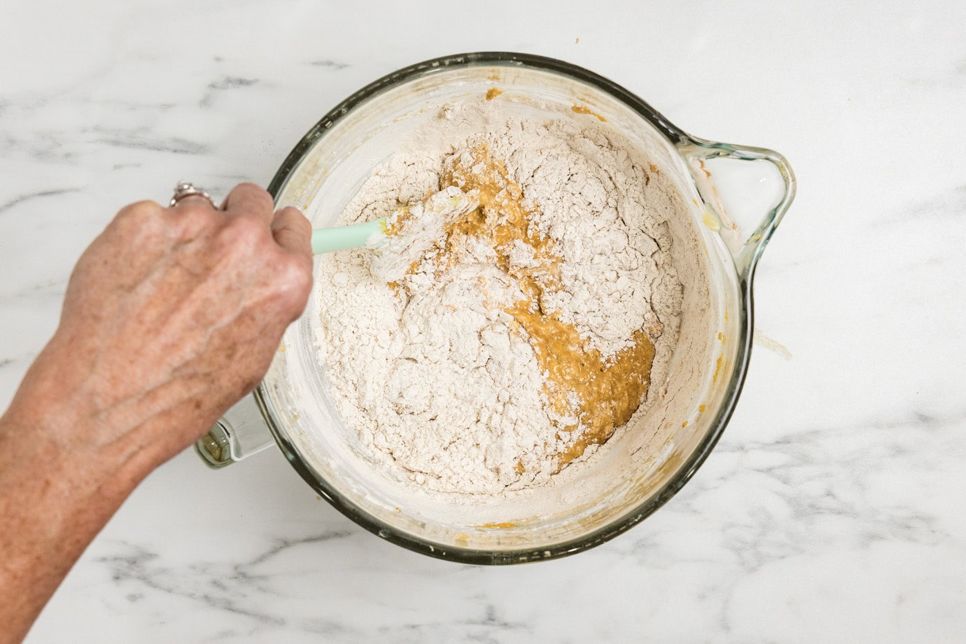 folding the rest of the flour into pumpkin batter with a rubber spatula