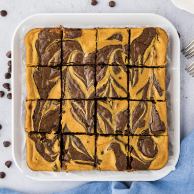 Close up photo of Pumpkin Cheesecake Brownies on a platter cut into squares