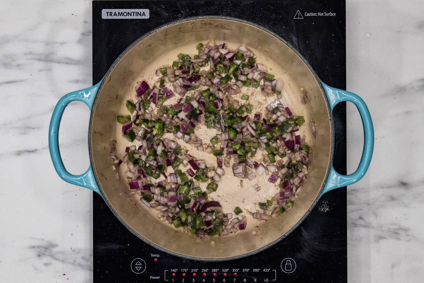 bell peppers, onions, and garlic sauteeing in a dutch oven