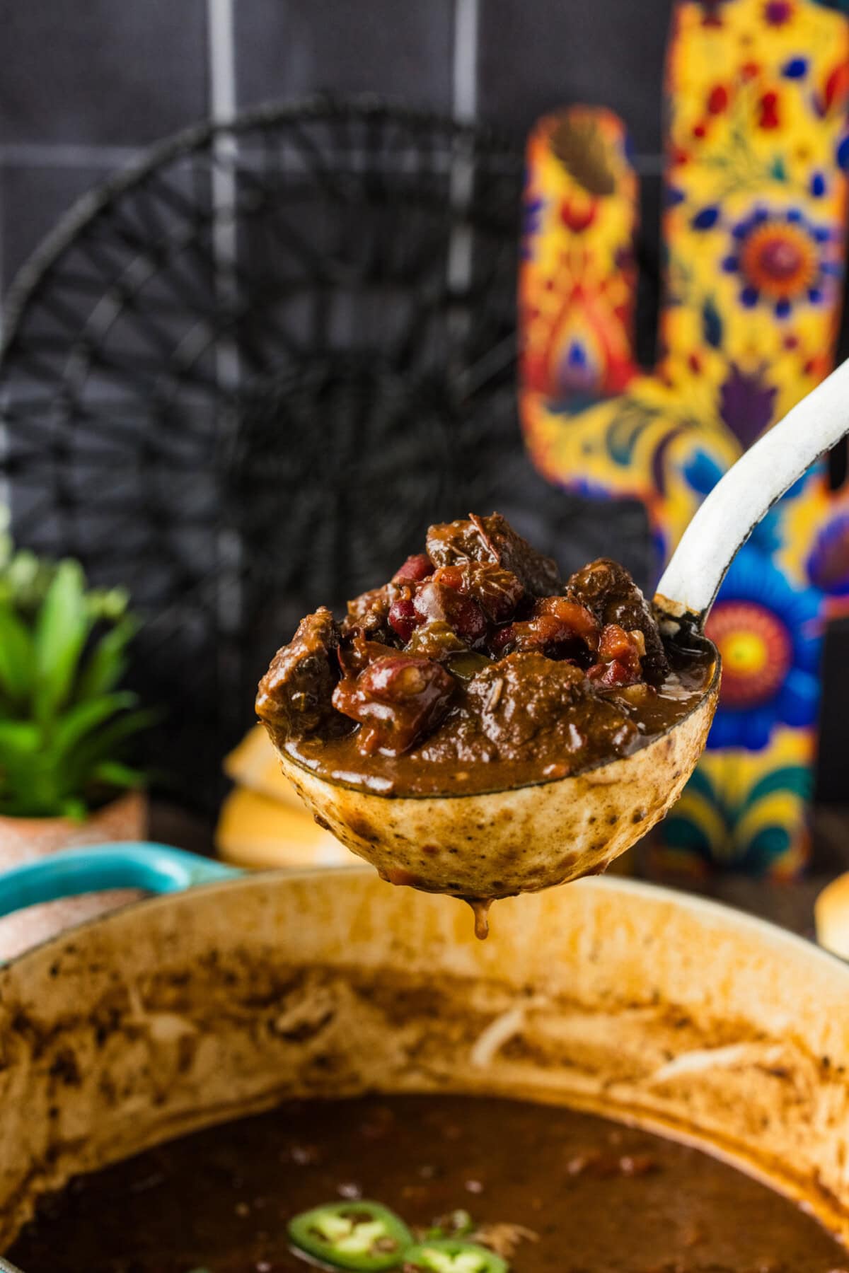 Ladle of Short Rib Chili held over a pot