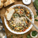 Bowl of Vegetable Rice Soup with bread to the side