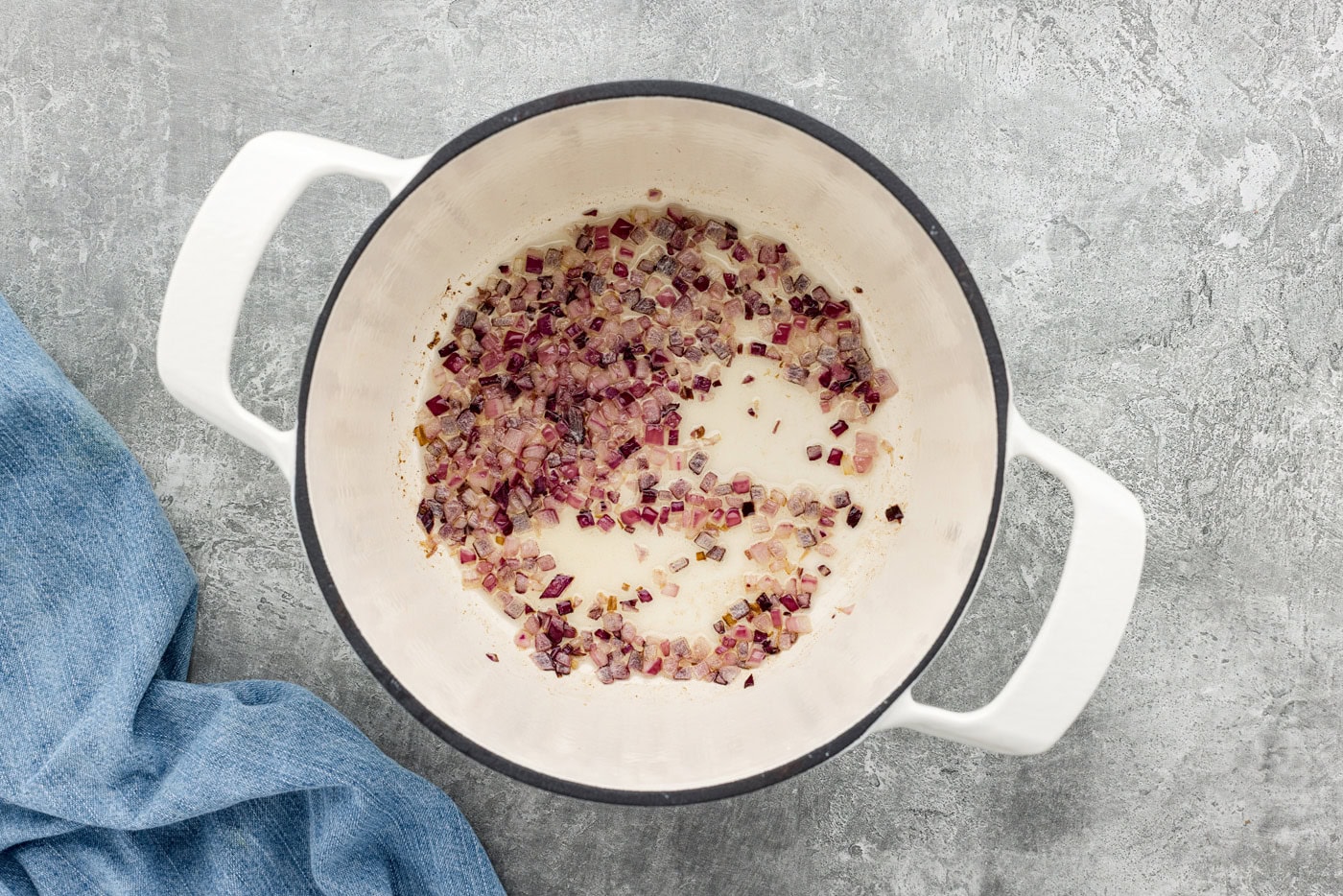 chopped red onion in a pot with olive oil