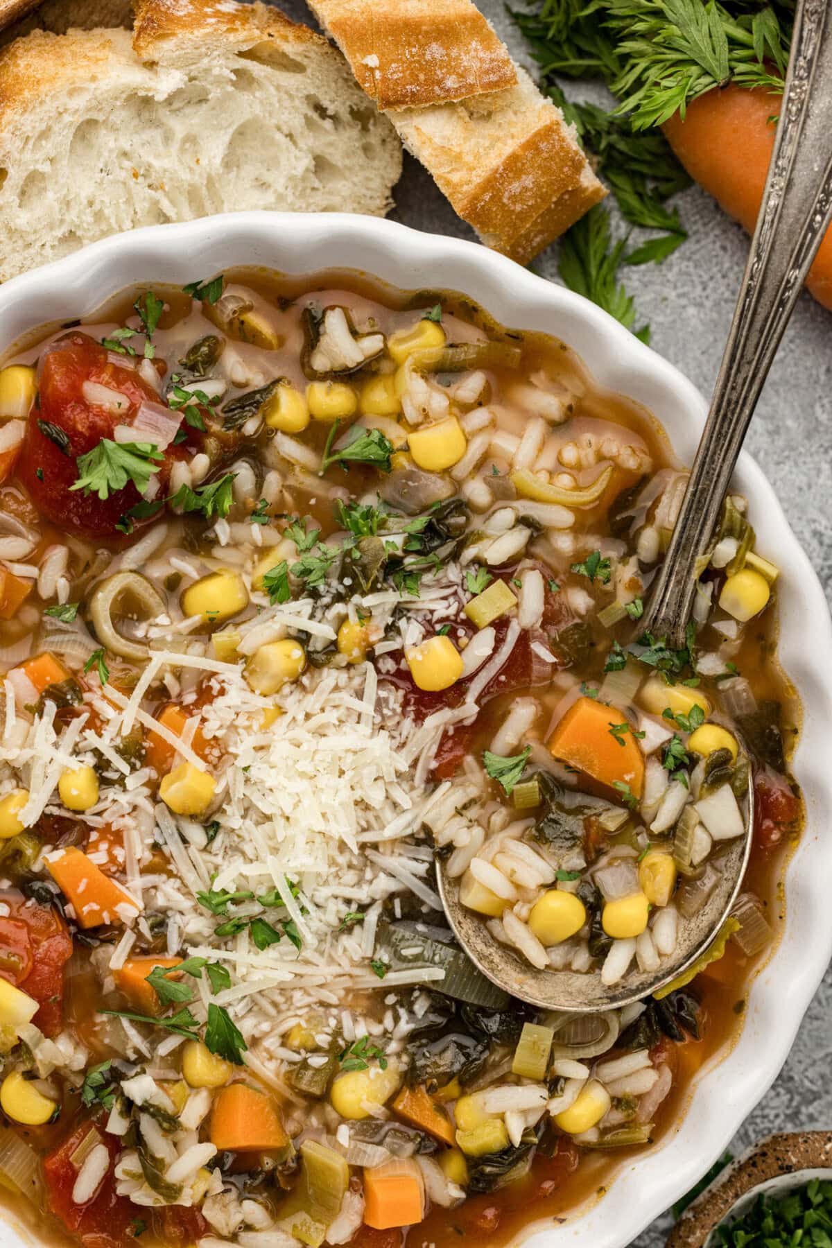 Close up photo of a bowl of Vegetable Rice Soup with a spoon in it