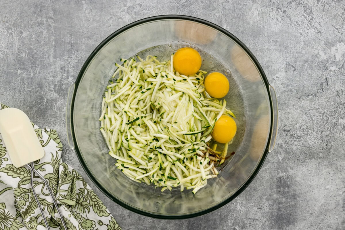 shredded zucchini, eggs, oil, and vanilla in a mixing bowl