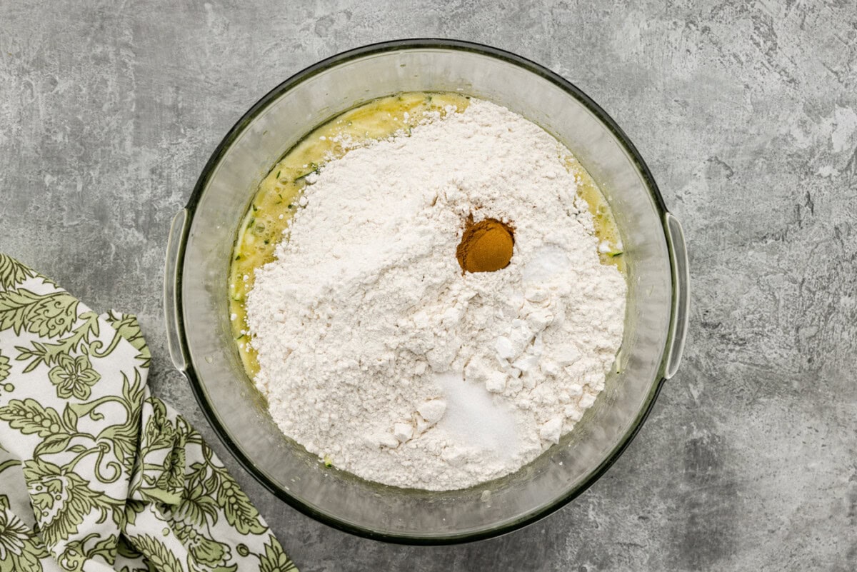 Dry ingredients added to zucchini mixture in a mixing bowl