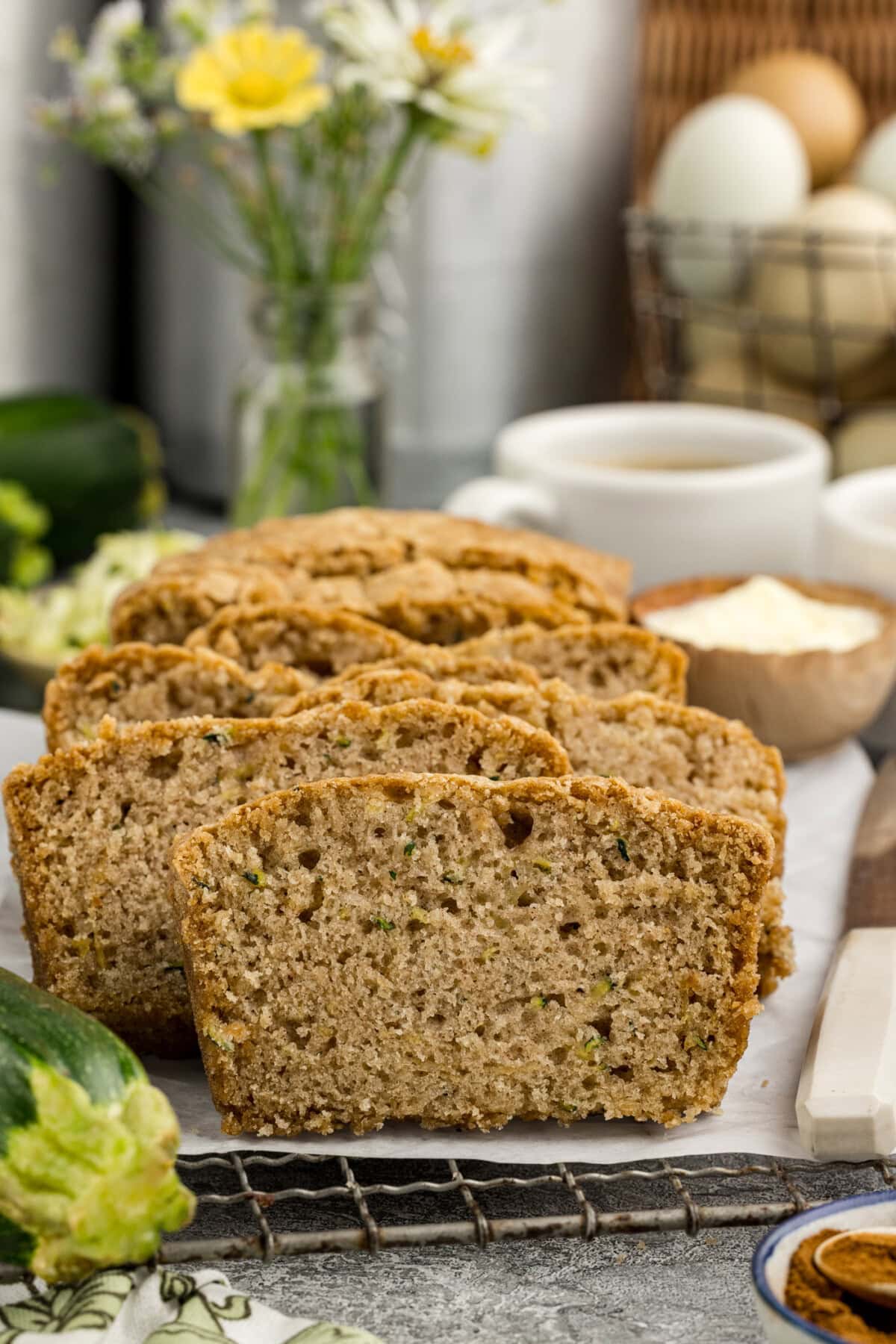 Slices of Zucchini Bread resting on a parchment lines wire rack