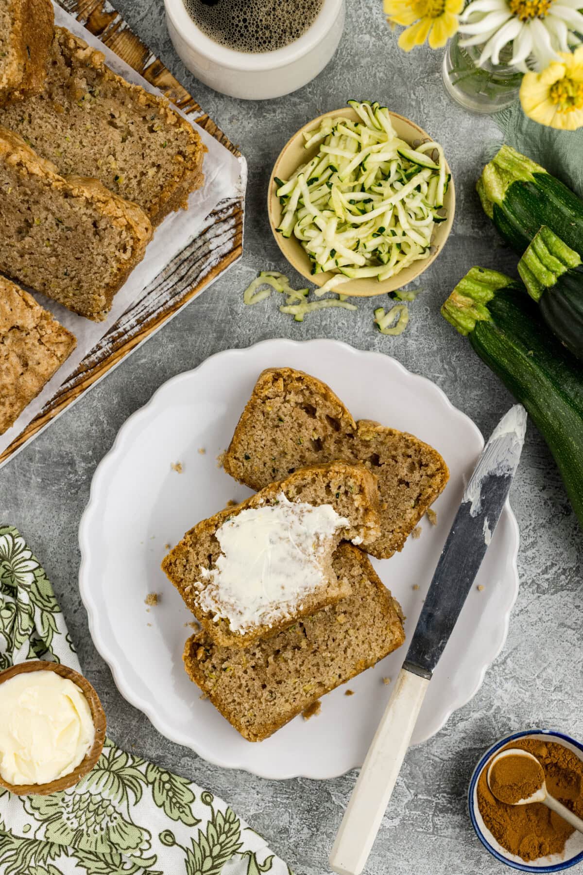 Slices of Zucchini Bread on a plate with one slice buttered