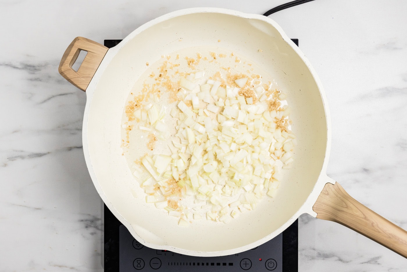 onion and garlic sauteed in a skillet with oil