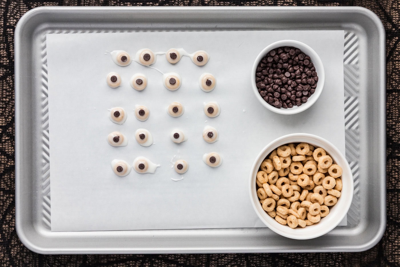 mini chocolate chip on top of glazed cheerios on a baking sheet 