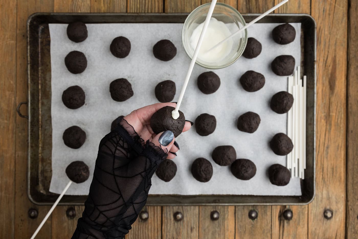 A lollipop stick inserted into the bottom of an Oreo truffle ball secured with chocolate
