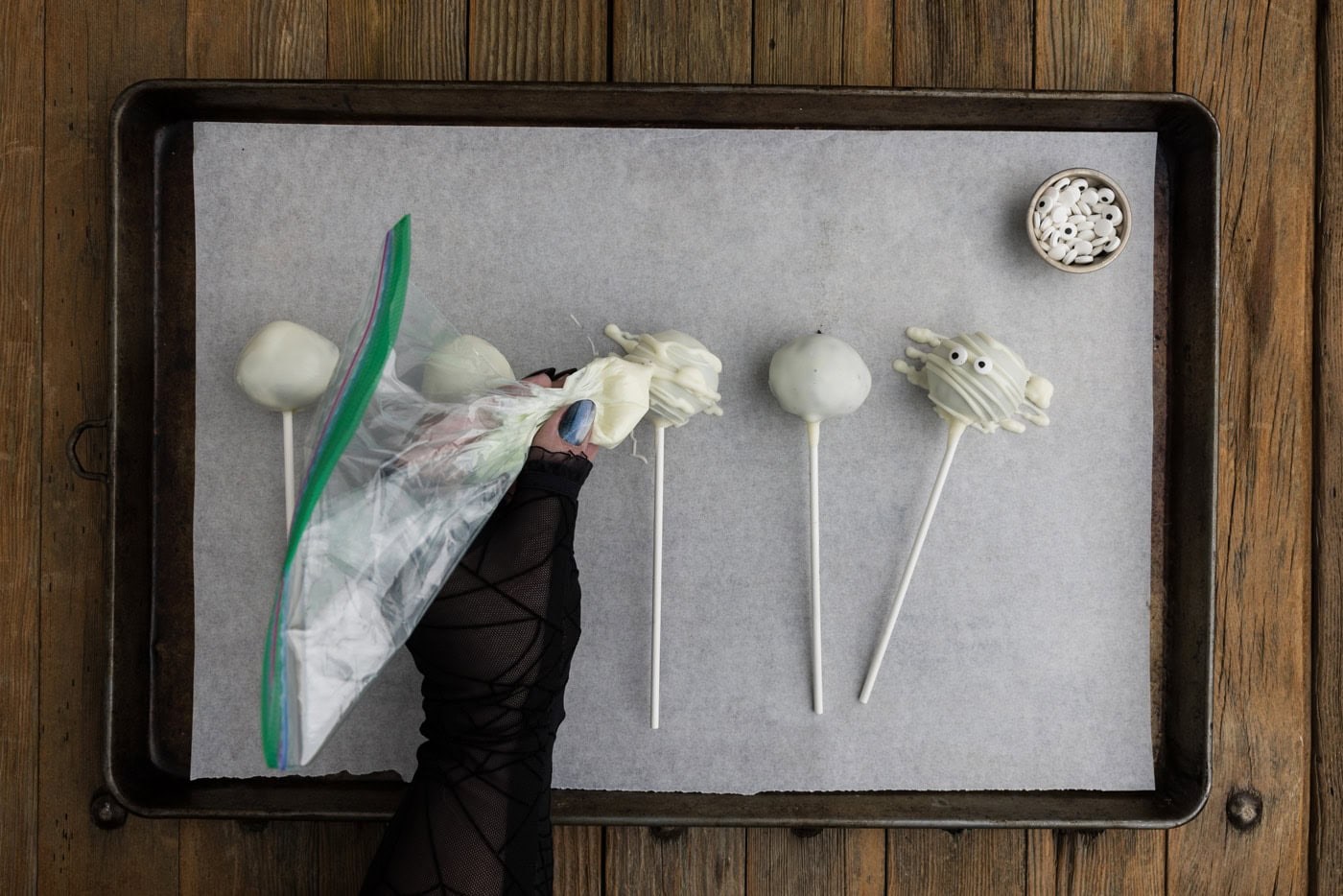 drizzling melted white candy wafers over the top of white chocolate coated Oreo truffles to look like mummy bandages