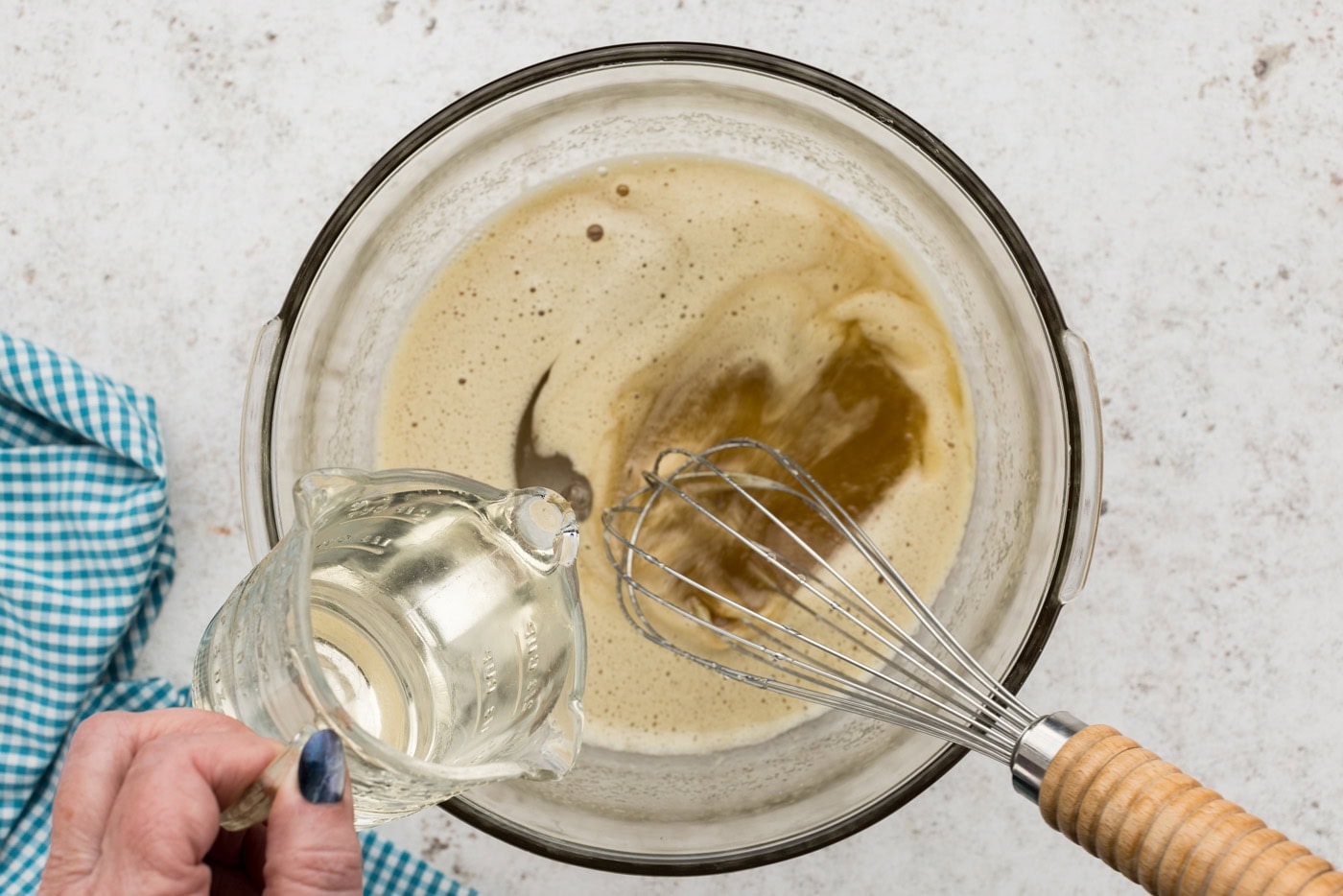 pouring cornstarch into sugar and egg mixture beating with a whisk