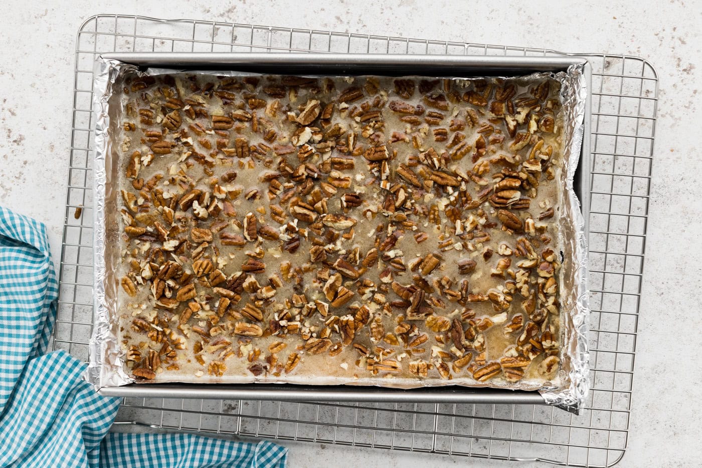 pecan pie filling added to a baking dish on top of shortbread crust