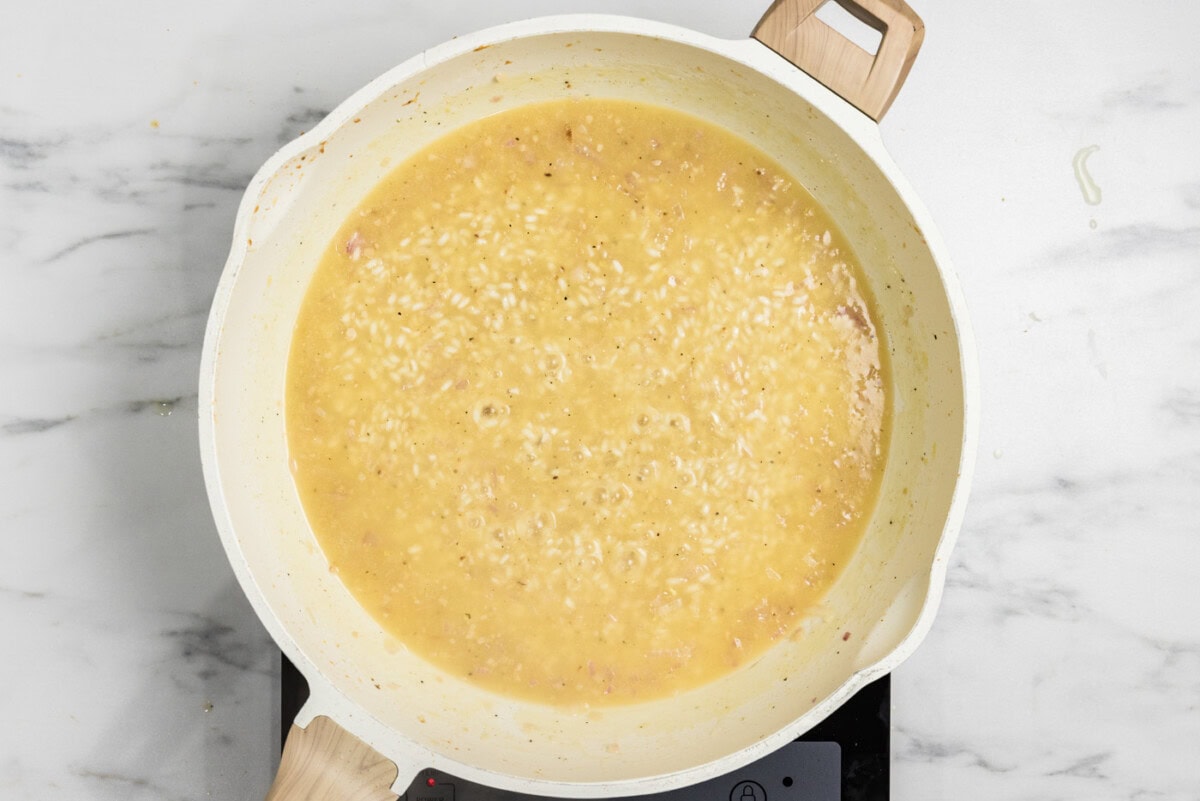 chicken broth added to skillet with risotto