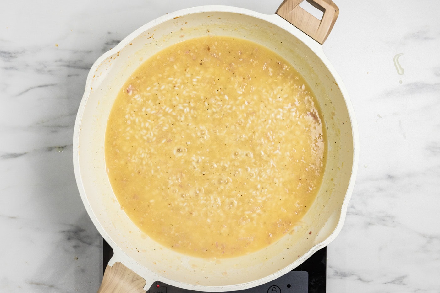 chicken broth added to skillet with risotto