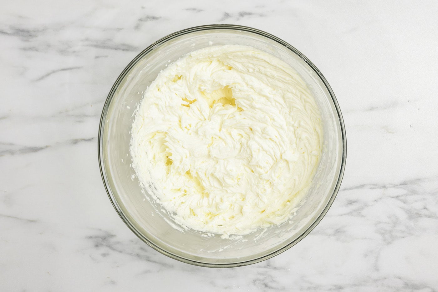 cream cheese, mascarpone cheese, and powdered sugar mixed in a bowl