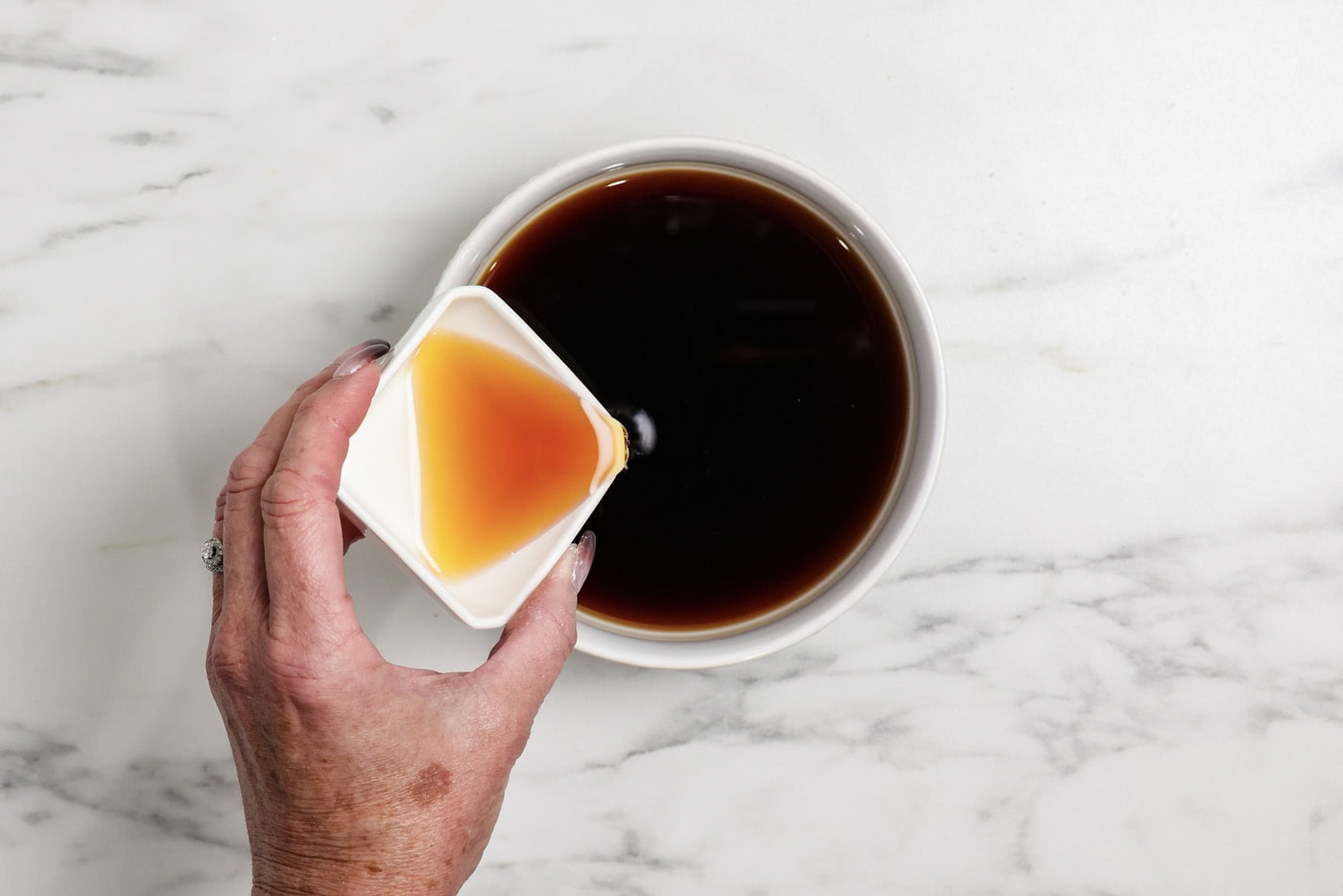 pouring Amaretto into instant espresso in a bowl