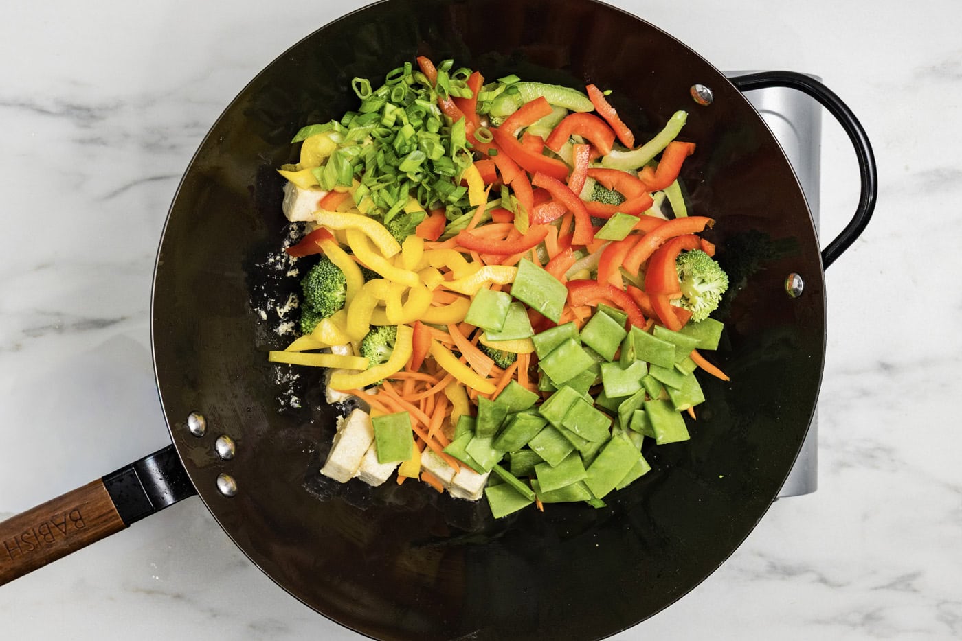 stir fry vegetables in a wok with tofu
