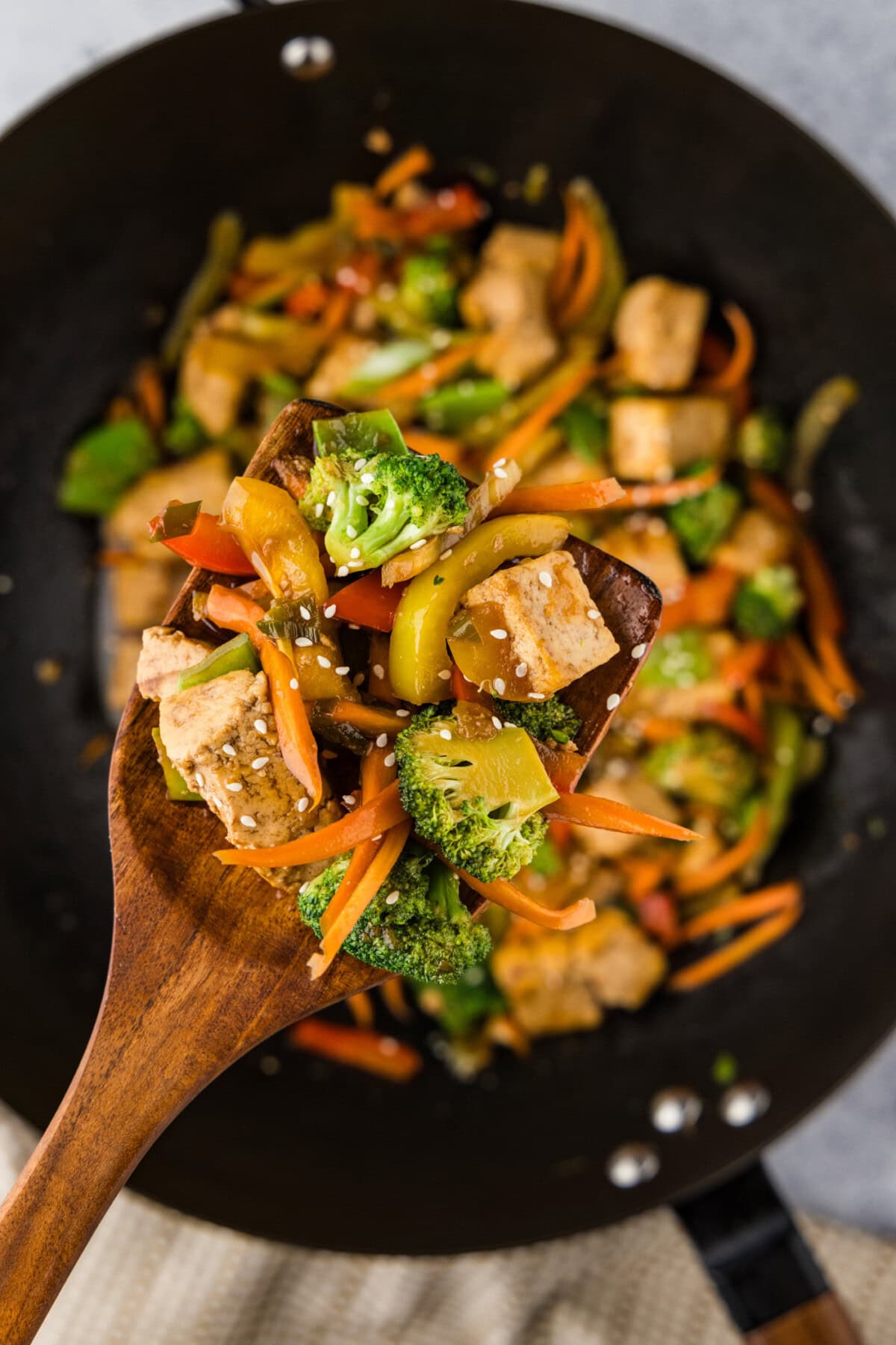 Spoonful of Tofu Stir Fry held above a wok of Tofu Stir Fry