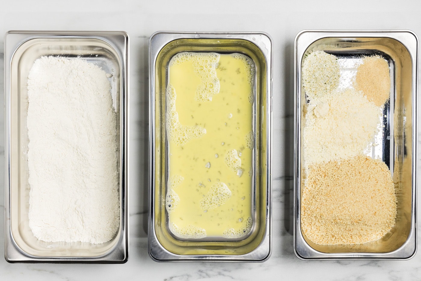 breading trays with flour in one, egg in the next, and panko bread crumb mixture in the third.