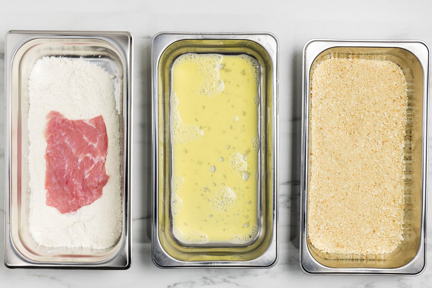 Veal cutlets in a breading pan of flour