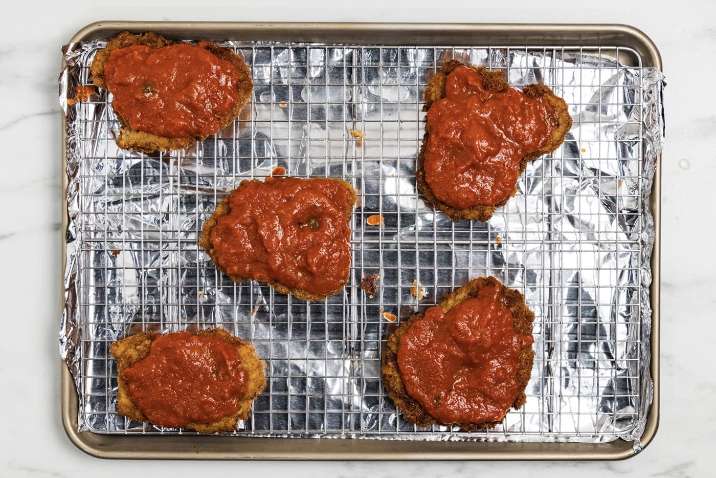 marinara sauce over cooked breaded veal cutlets