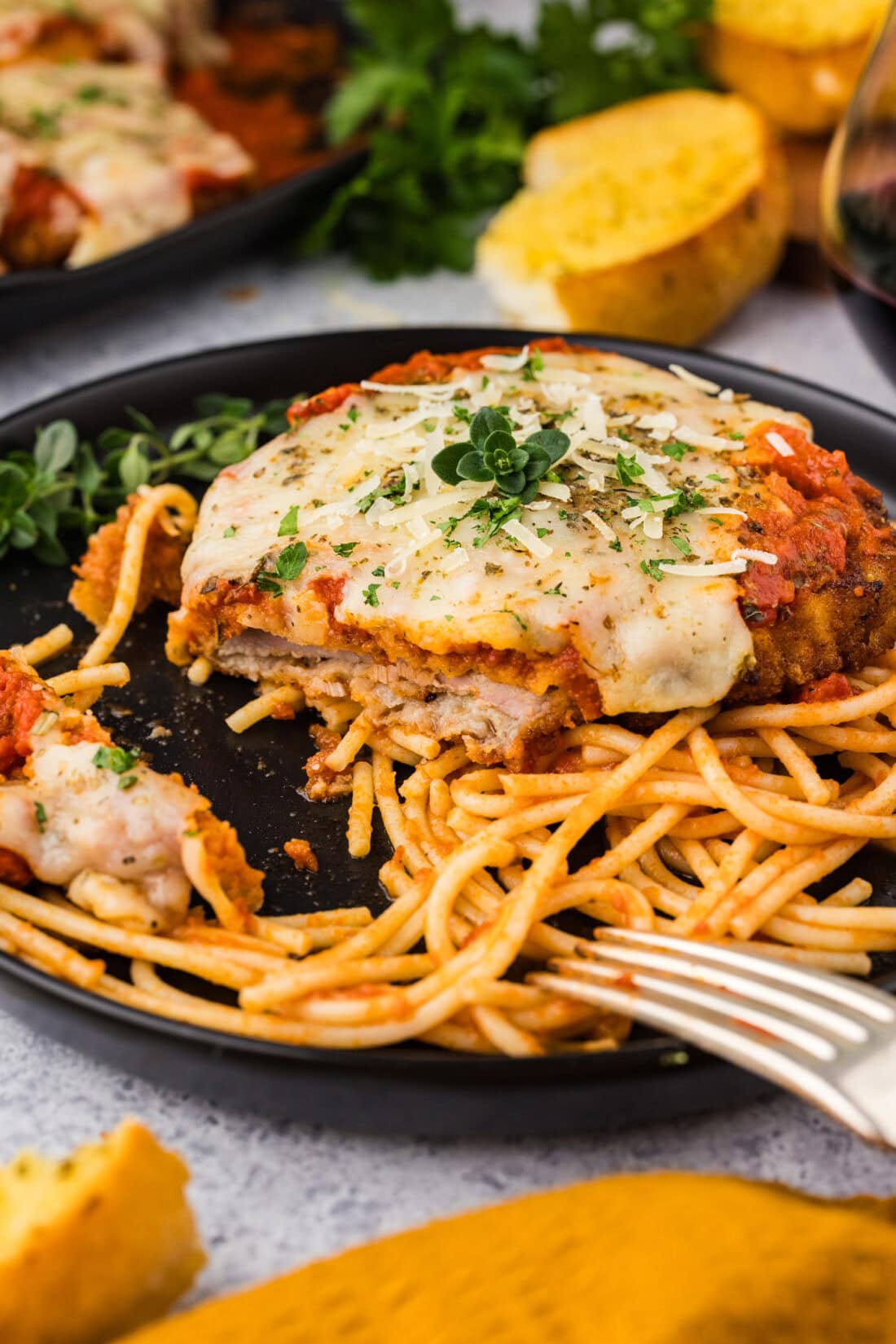 Plate of Veal Parmesan on spaghetti with a bite removed