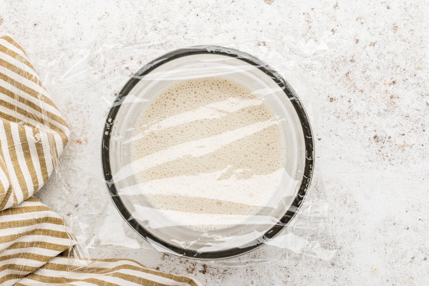 sponge ingredients in a bowl covered with plastic wrap
