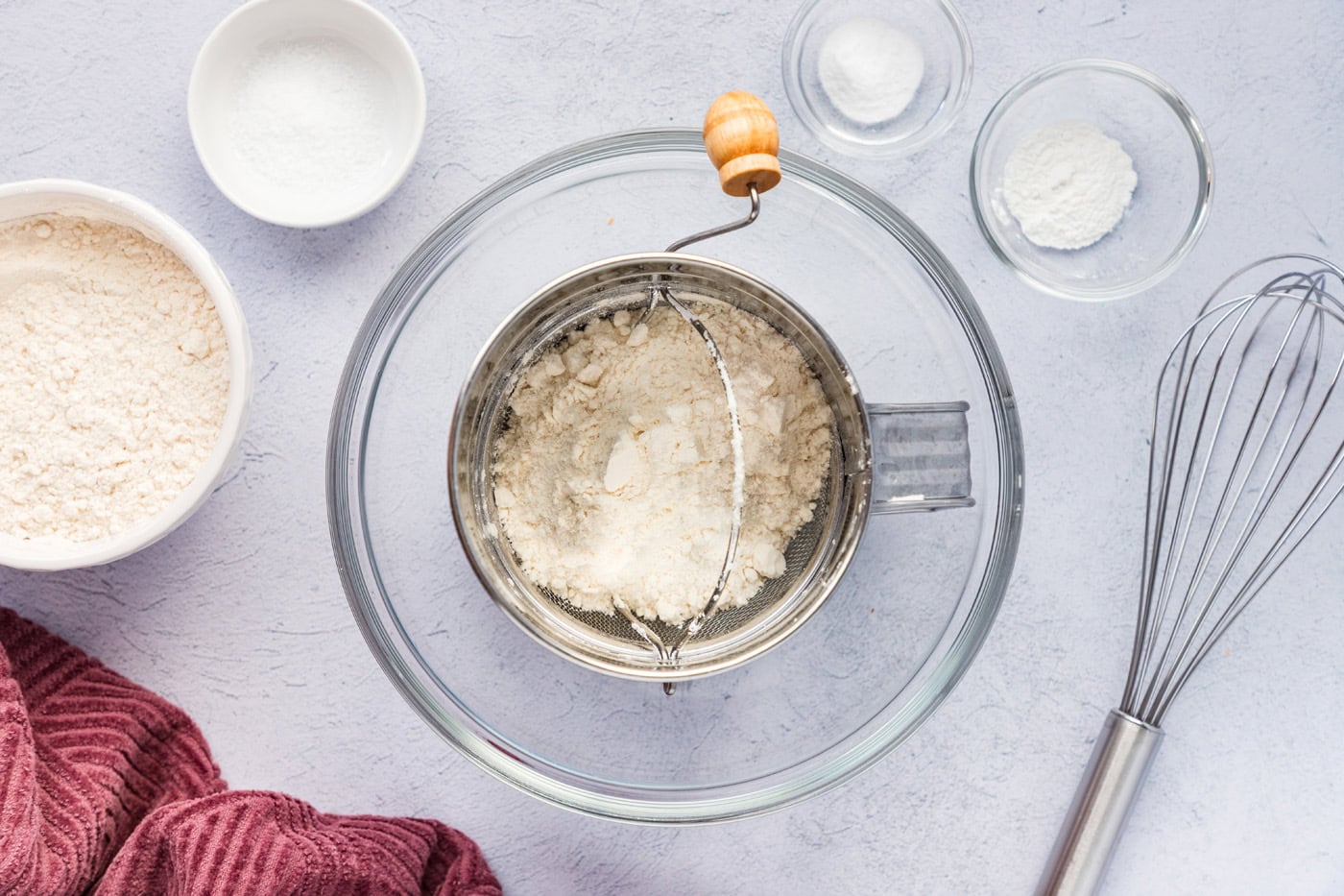 sifting flours, baking soda, and baking powder in a bowl