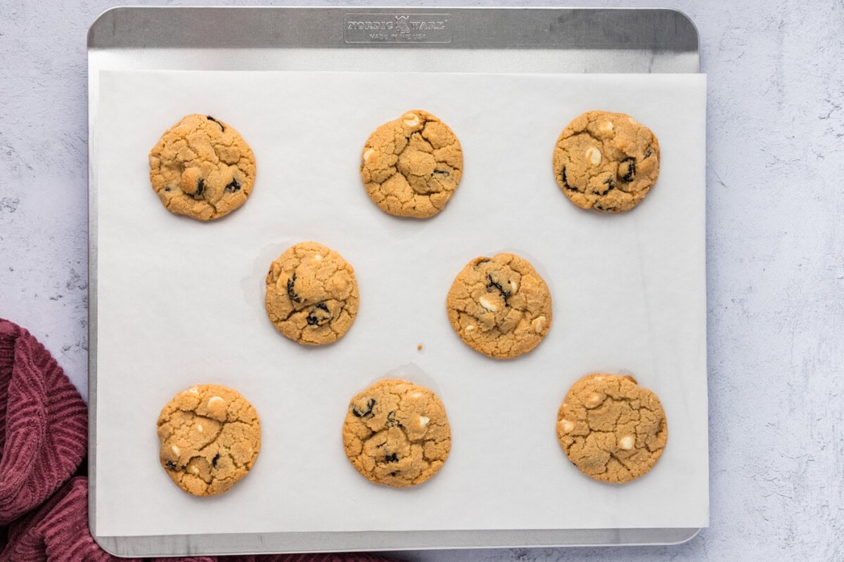 baked cherry white chocolate chip cookies on a parchment lined baking sheet