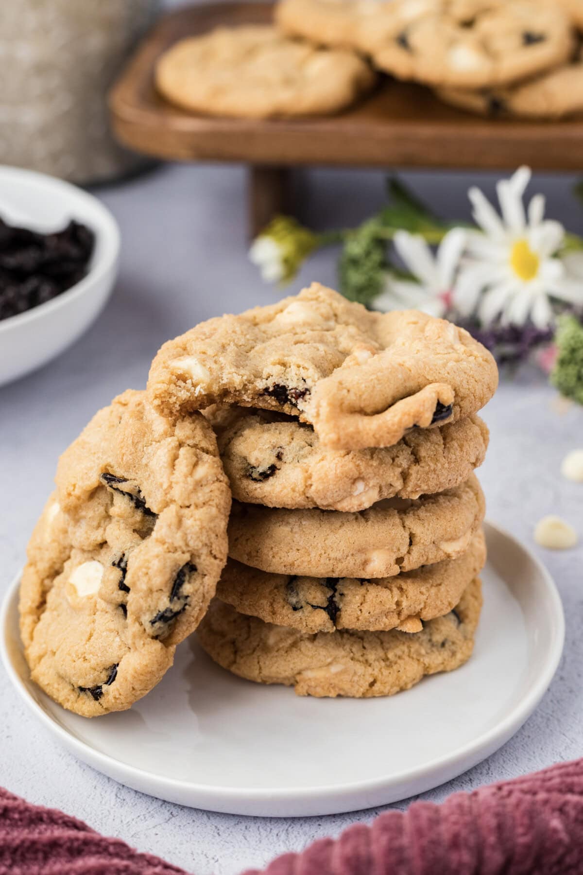 Stack of Cherry White Chocolate Chip Cookies with a bite taken out of the top cookie
