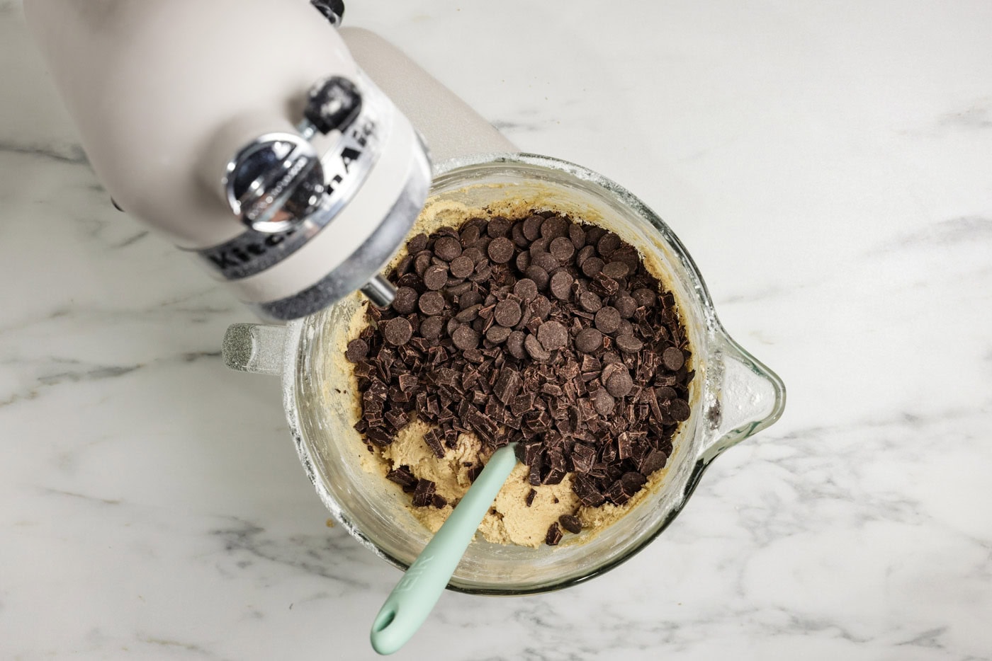 chocolate chip and chocolate chunks added to bowl of cookie dough batter