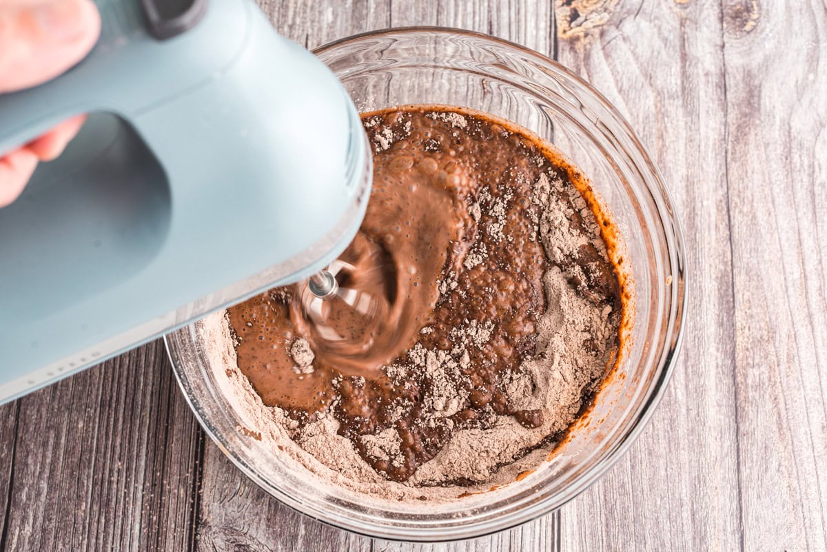Bowl of pudding mix and milk being beaten with a hand mixer