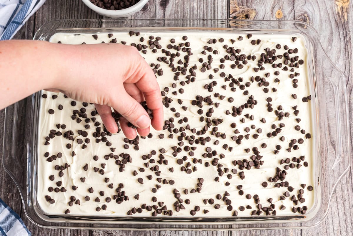 Mini chocolate chips being sprinkled over the cool whip