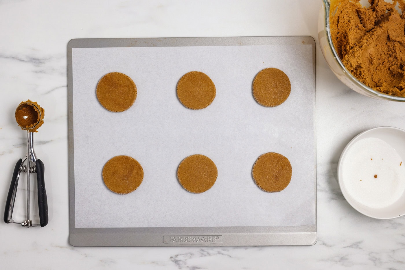 flattened gingersnap cookie dough on a baking sheet