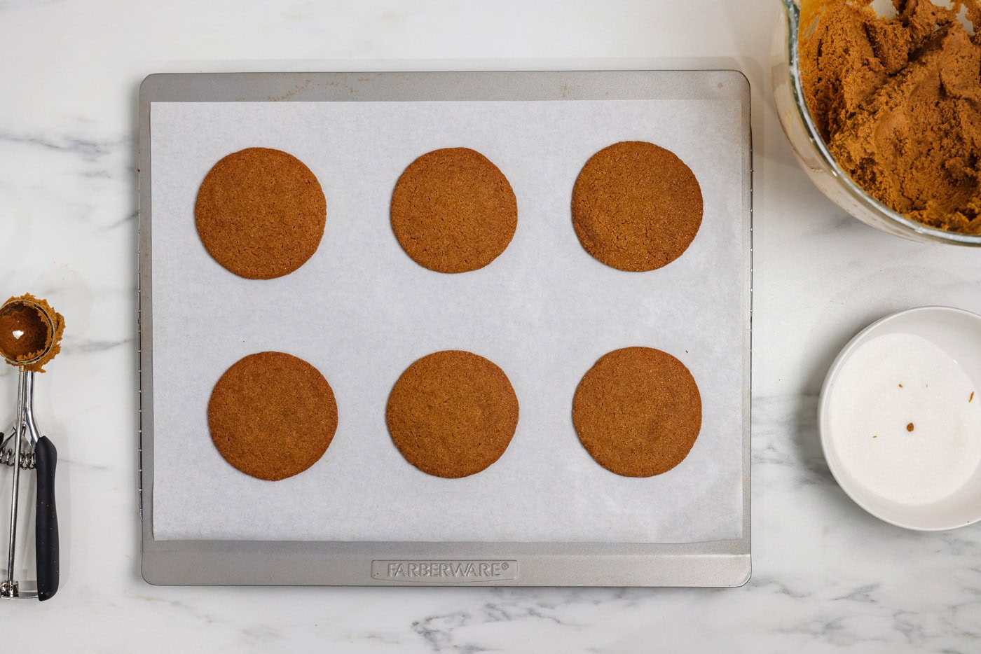 baked crispy gingersnap cookies on a baking sheet