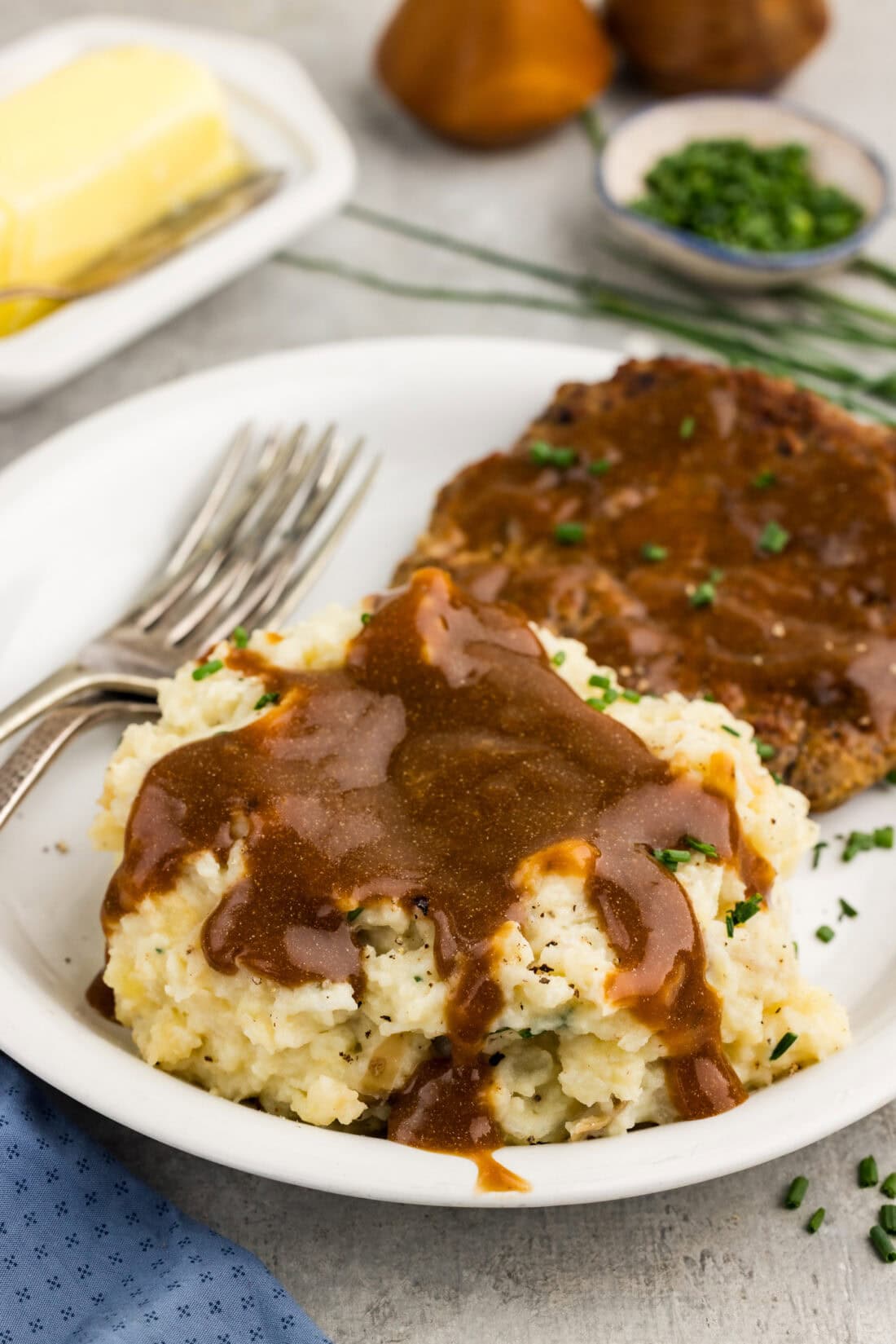 Crockpot Mashed Potatoes on a plate topped with gravy