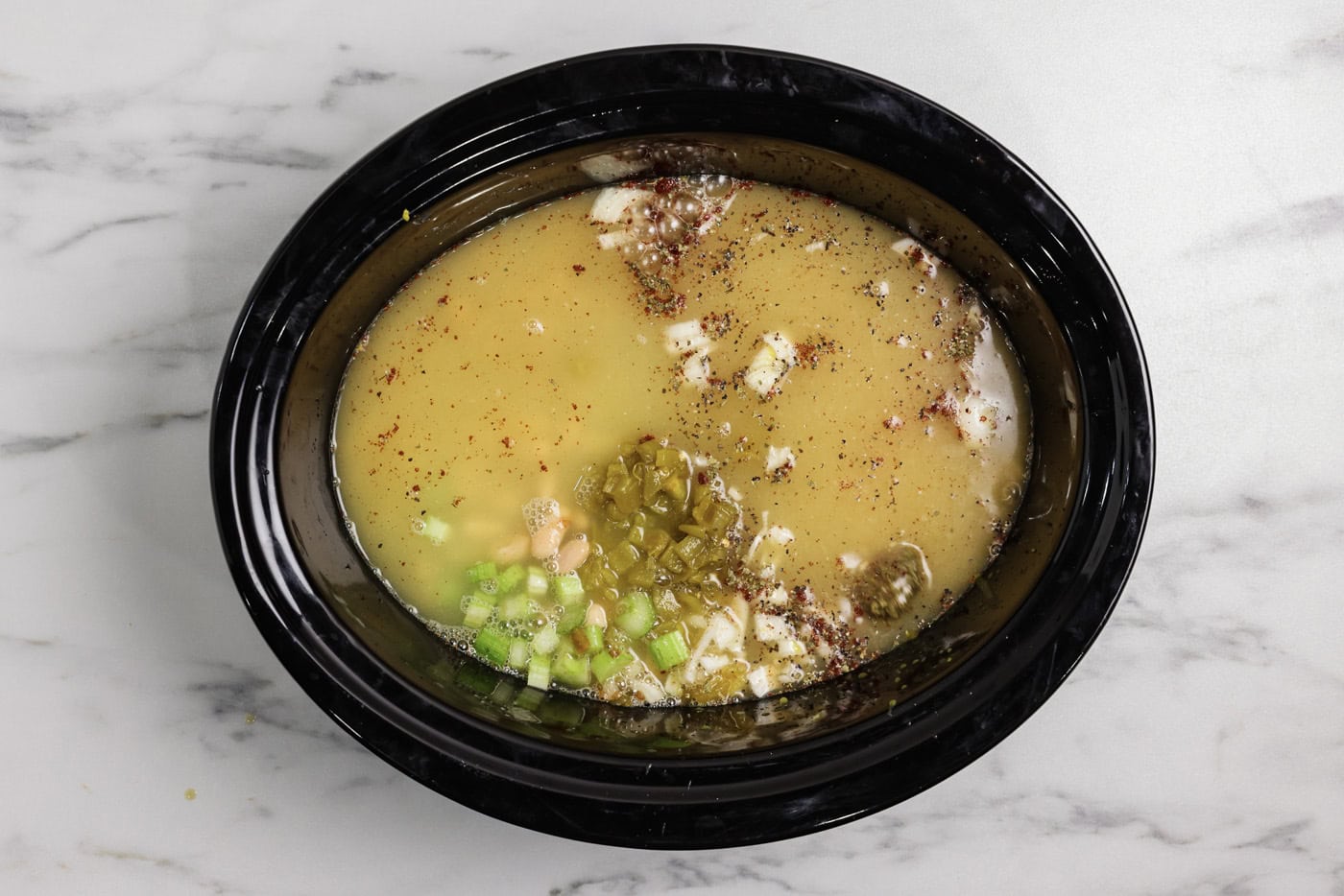 chicken broth added to crockpot with white chicken chili ingredents