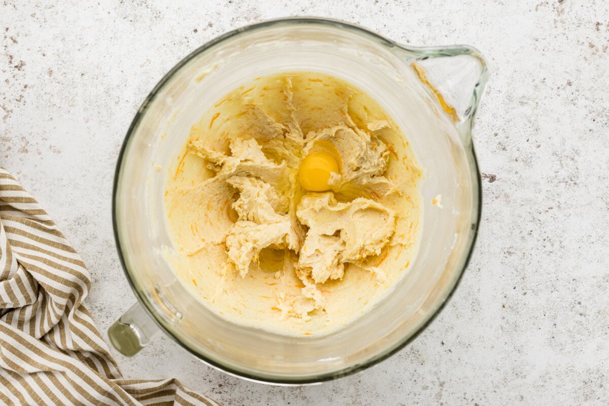 egg added to butter and sugar mixture in stand mixer bowl