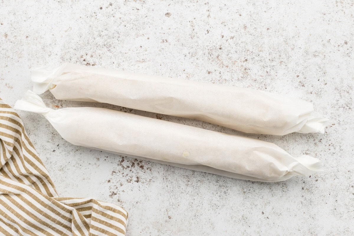 two roll of icebox cookie dough wrapped in parchment paper