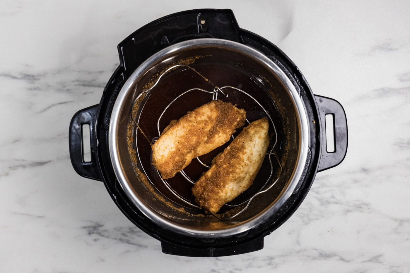 cooked chicken breasts in honey garlic sauce in a pressure cooker