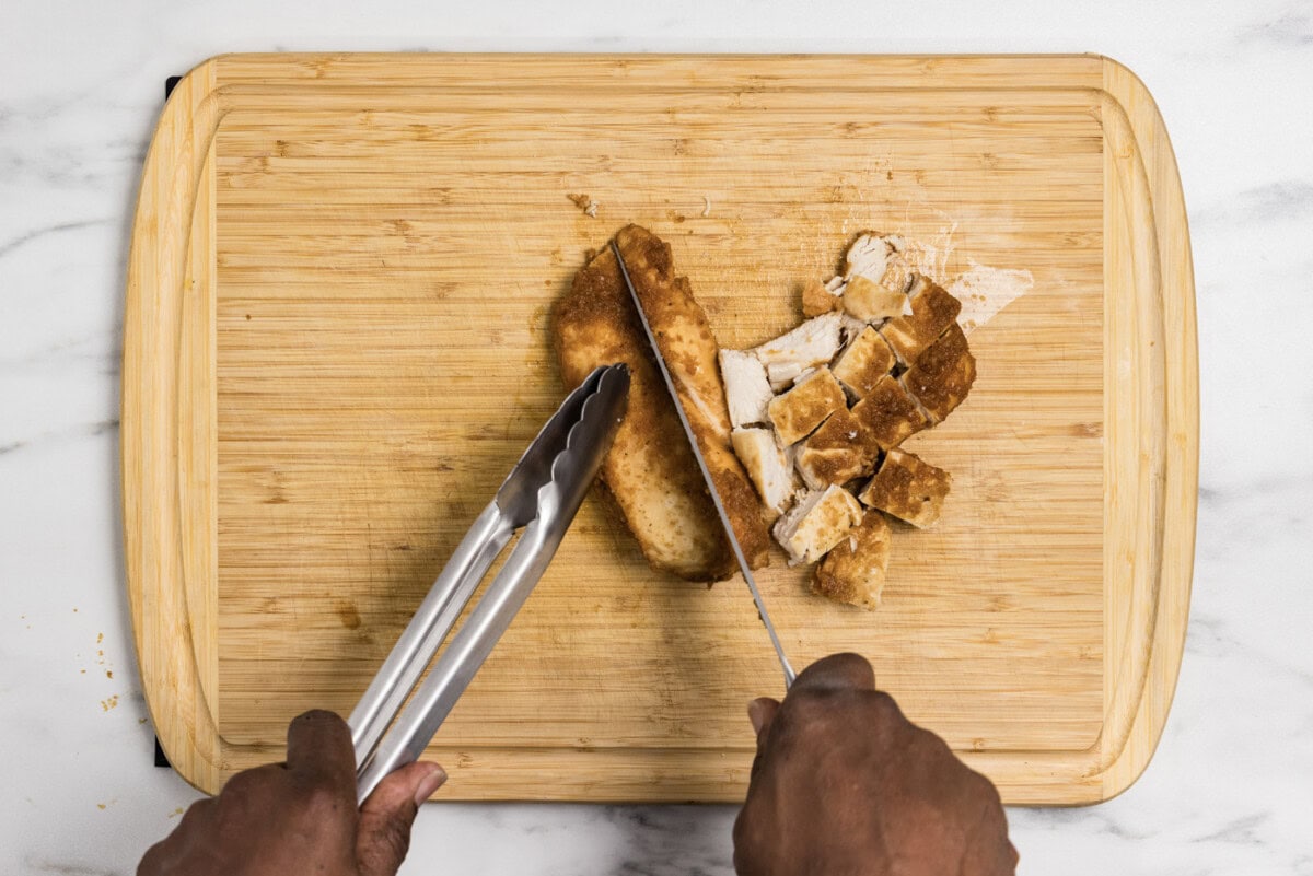 slicing chicken on a cutting board