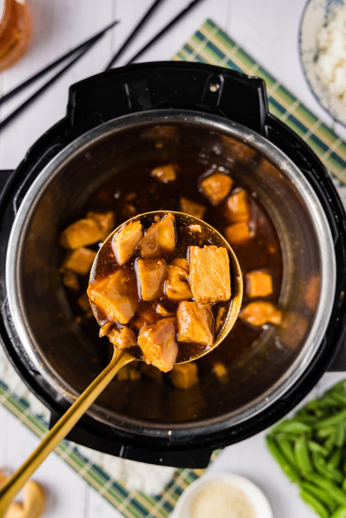 Spoonful of Instant Pot Honey Garlic Chicken held above an Instant Pot