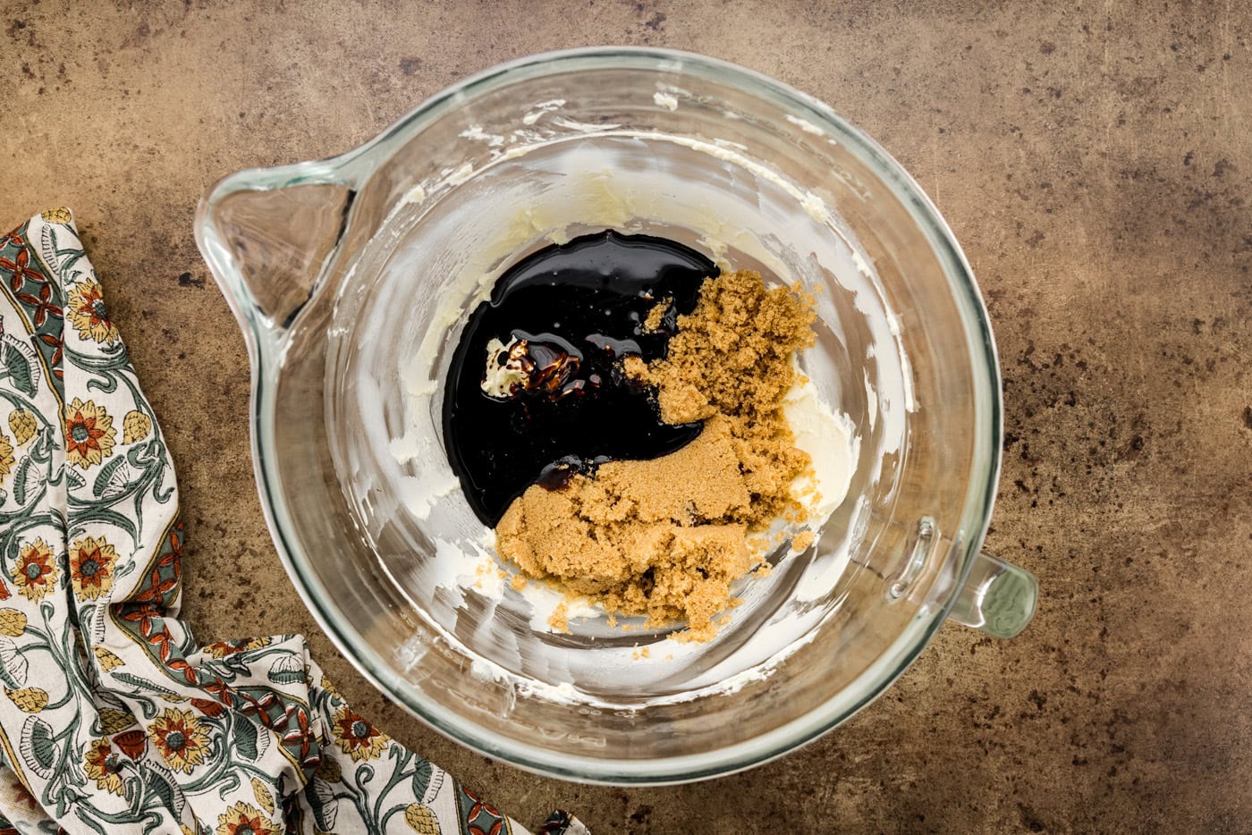 molasses and brown sugar added to butter in a mixing bowl