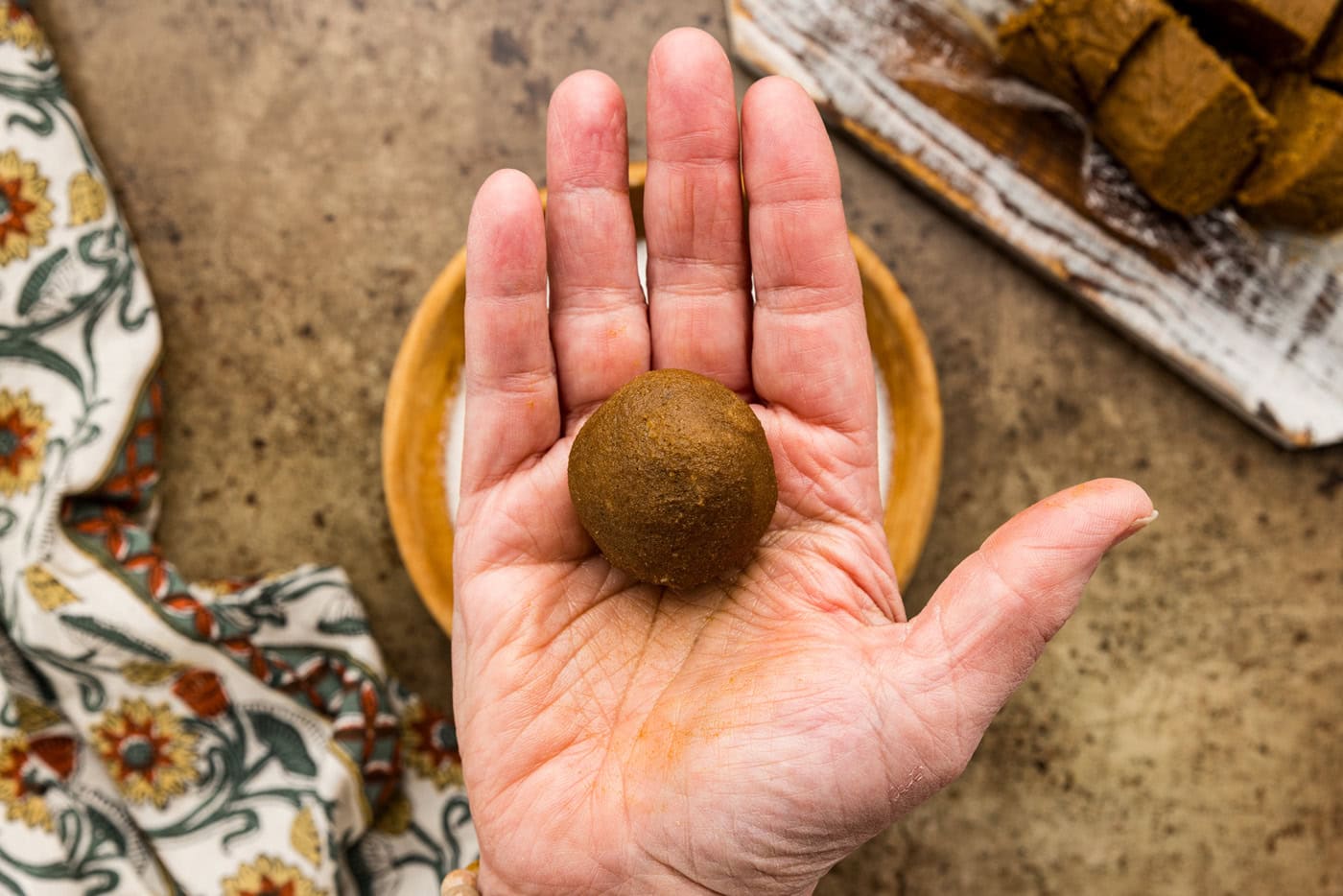 molasses cookie dough ball in the palm of a hand
